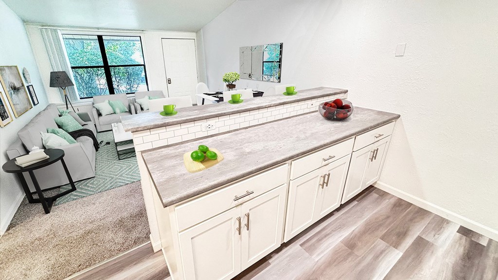 A kitchen with a large island and a dining table with chairs.