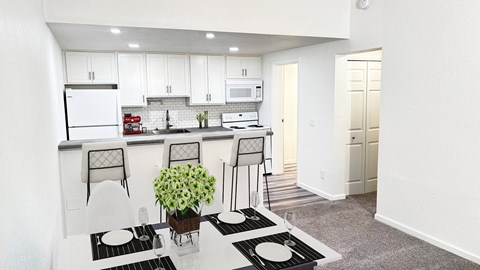 A kitchen with white cabinets and a black and white rug.