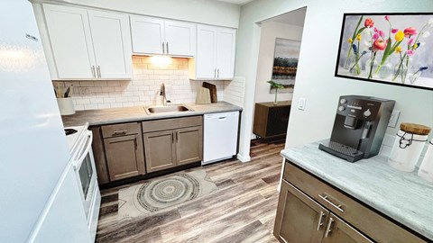 A kitchen with a white refrigerator and wooden cabinets.