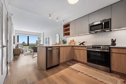 A modern kitchen with wooden cabinets and a stainless steel oven.