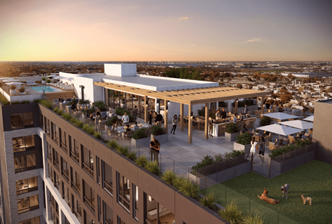 A modern building with a rooftop terrace and people enjoying the outdoor space.
