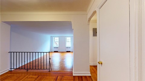 A room with a wooden floor and a white door.