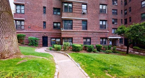 A brick building with a green lawn in front.