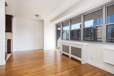 A large empty room with wooden floors and white walls.