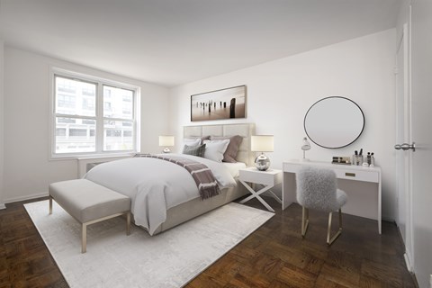 A bedroom with a large bed, a chair, and a table with a mirror.