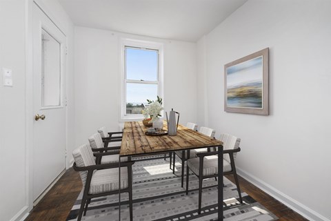 A dining room with a wooden table and chairs.