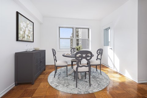 A dining room with a table set for four.