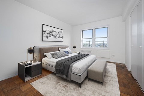 A bedroom with a large bed and a window overlooking the ocean.