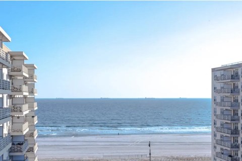 A beachfront building overlooks a calm ocean.