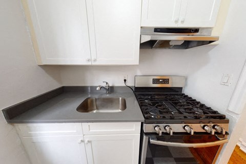A kitchen with a stove and sink.