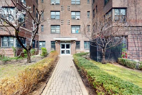 A brick building with a pathway leading to the entrance.