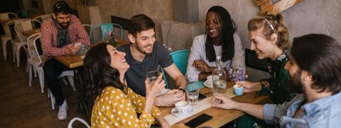 A group of people are sitting around a table in a casual setting.