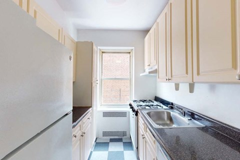 A kitchen with a checkered floor and white appliances.