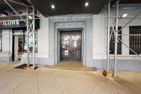 The image shows a building entrance with a large glass door and a decorative frame above it.