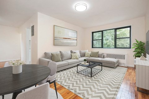 A living room with a grey couch, a coffee table, and a painting on the wall.