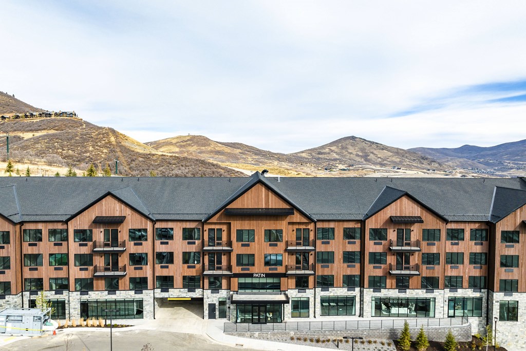 a large hotel building with mountains in the background