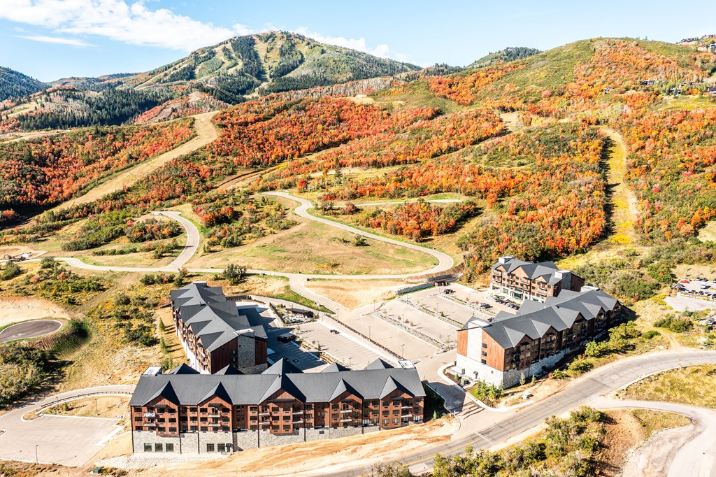 an aerial view of a building in front of a mountain