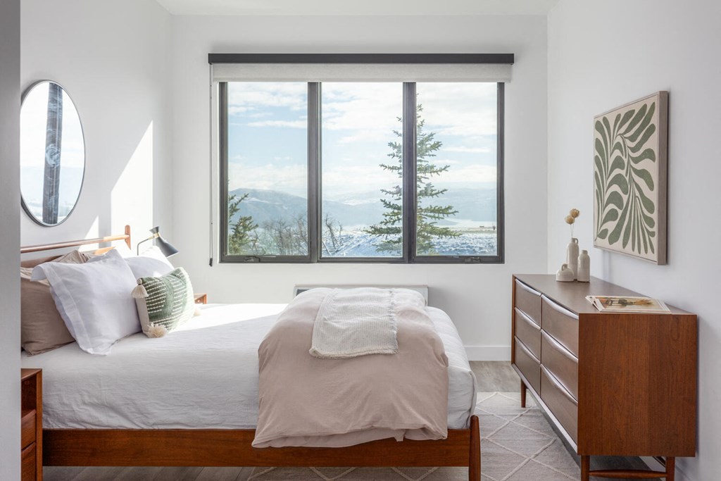 a bedroom with a bed and a window with a mountain view