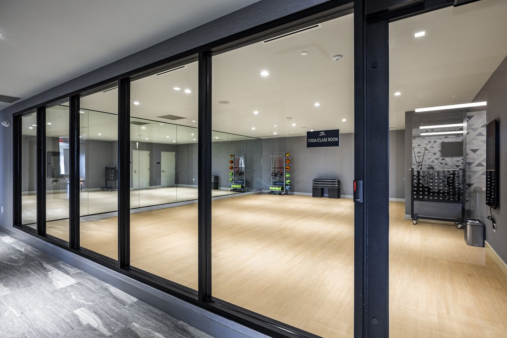 a gym with a wooden floor and large glass windows