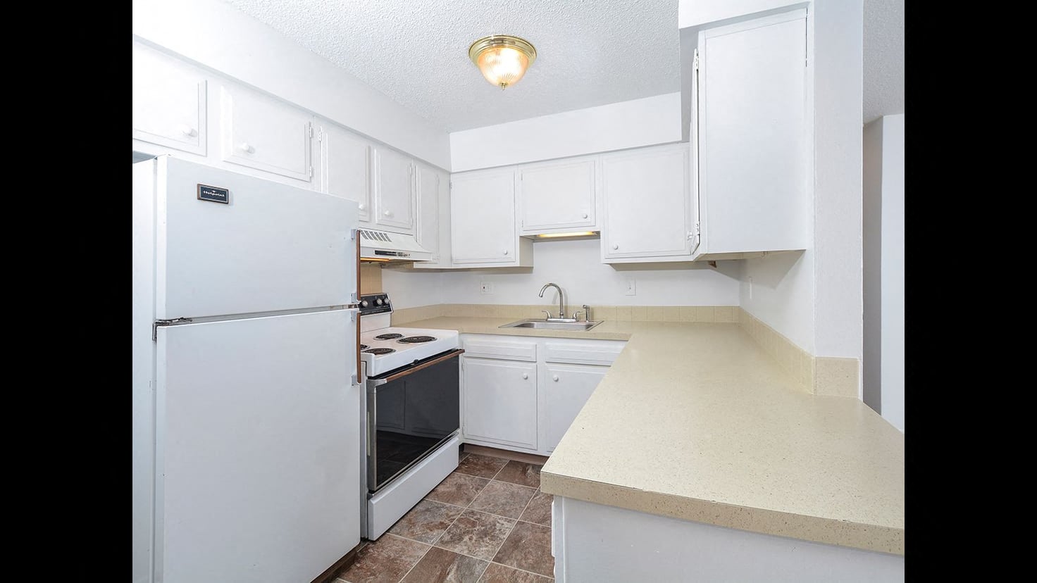 a kitchen with white cabinets and a white refrigerator