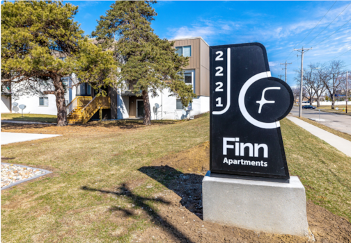 a sign in front of a building that says apartments
