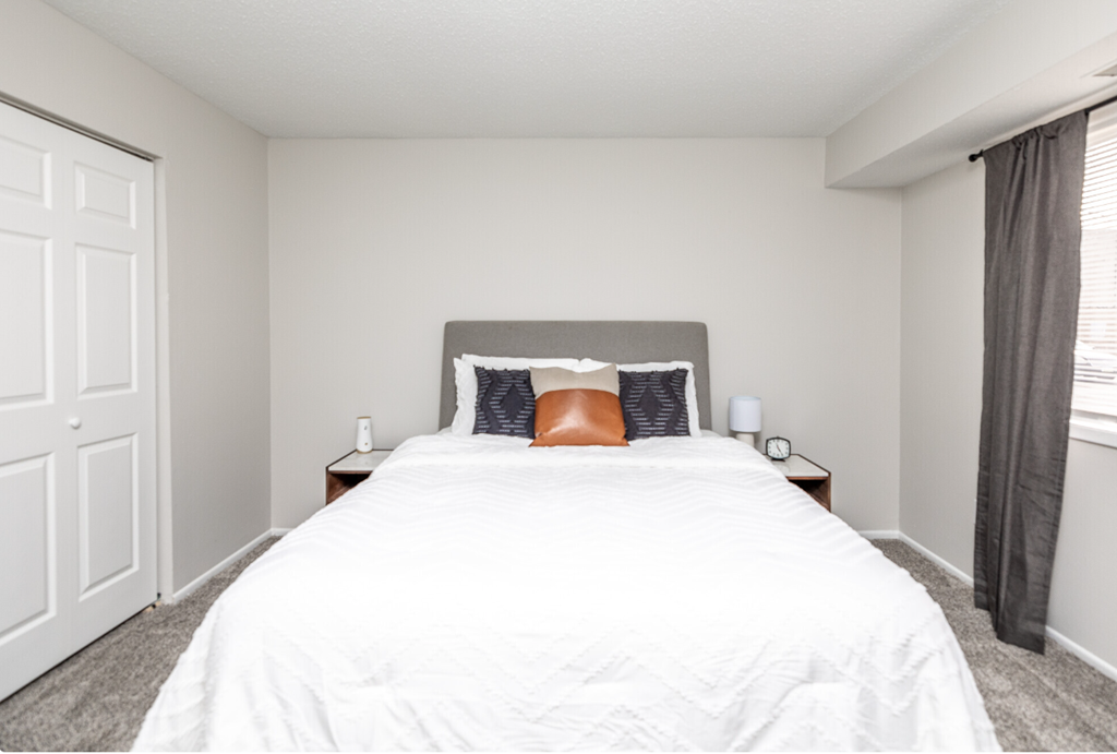 a bedroom with a large white bed and a window