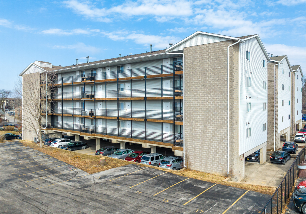 a large apartment building with cars parked in front of it