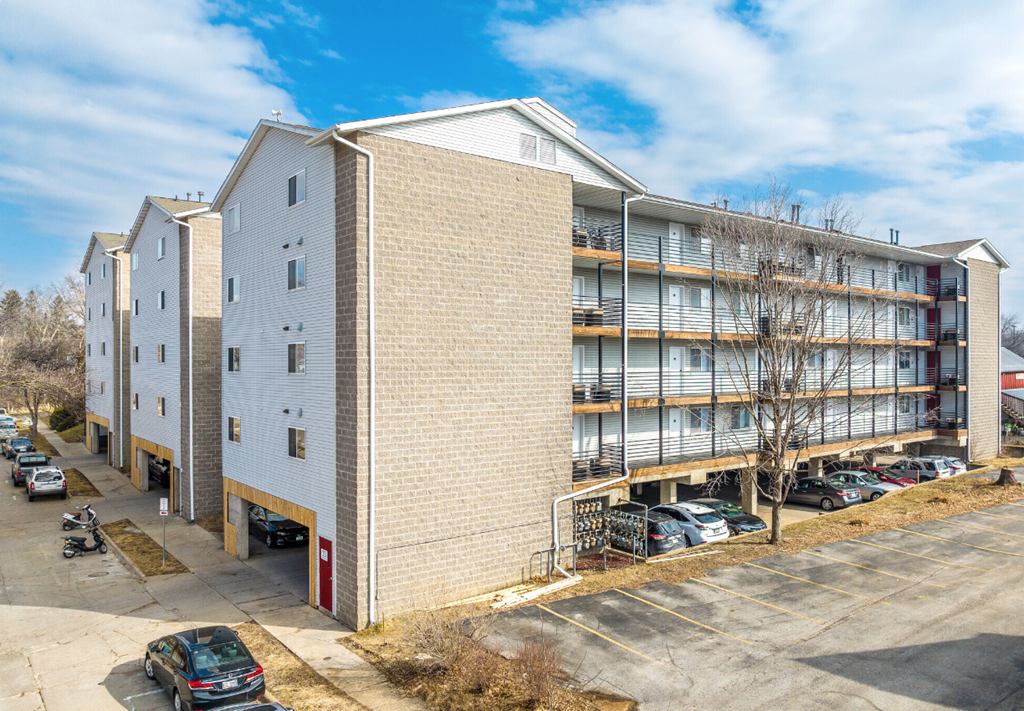 a large apartment building with cars parked in front of it