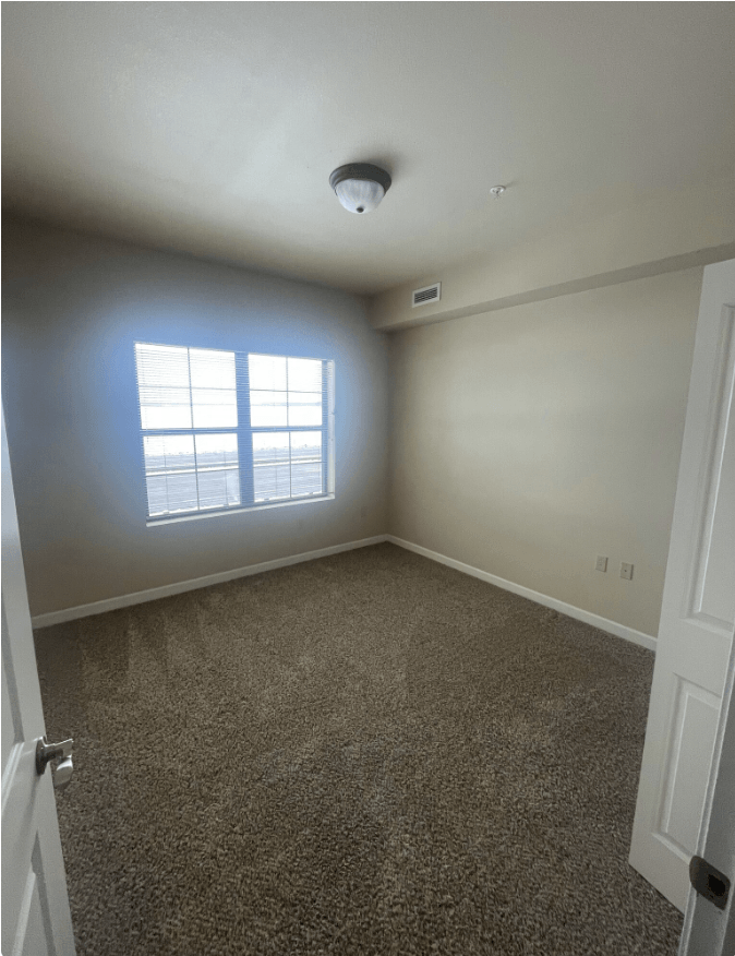 an empty room with carpet and a window