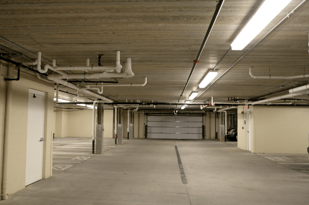 the inside of a building with a long hallway and garage doors