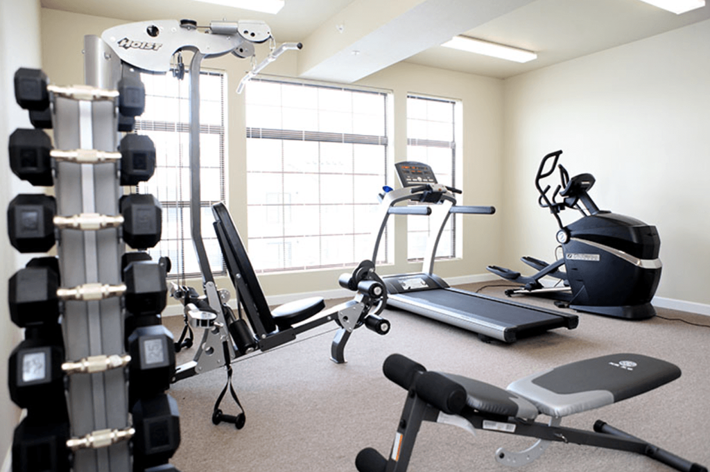a gym with weights and other exercise equipment in an empty room