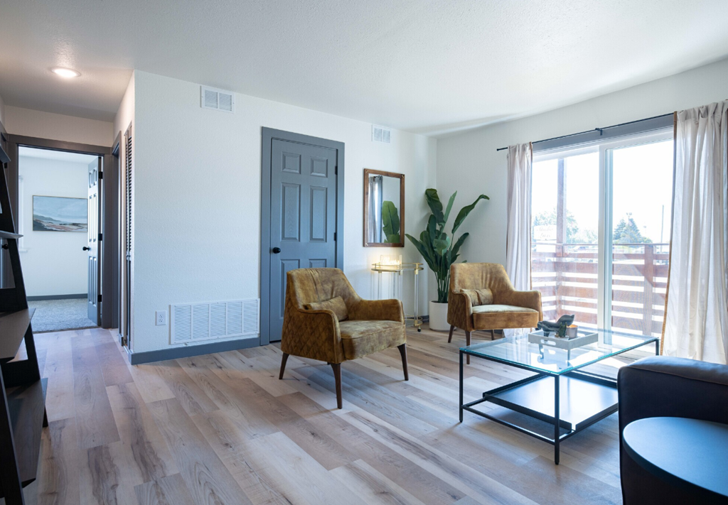 a living room with two chairs and a glass coffee table