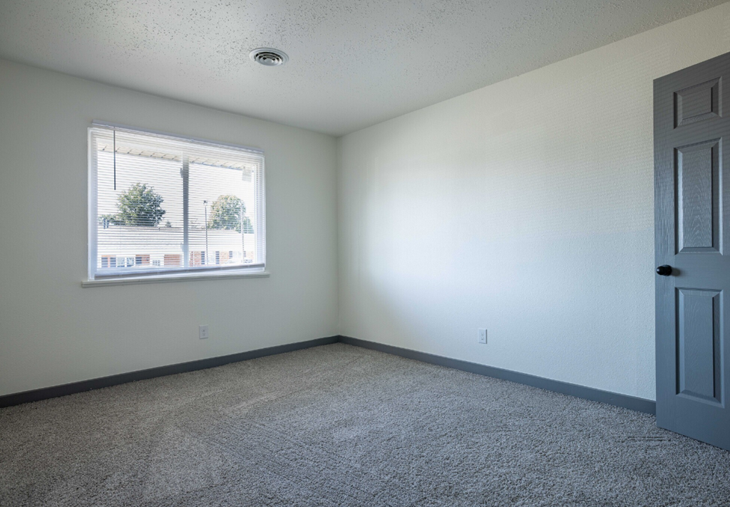 an empty room with a window and a door