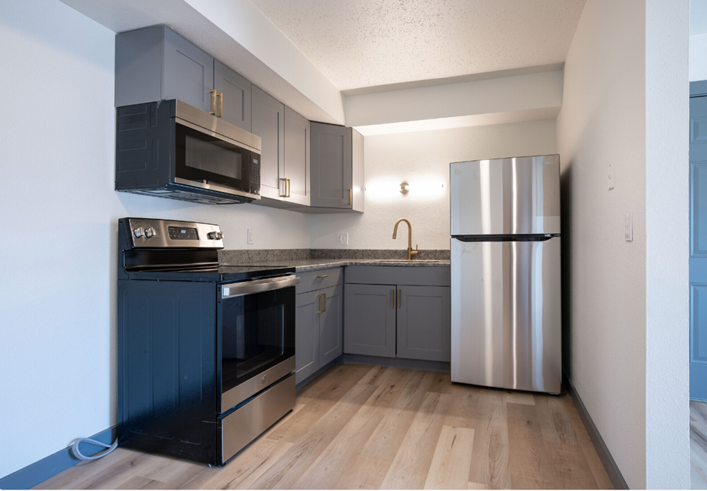 an empty kitchen with stainless steel appliances and blue cabinets