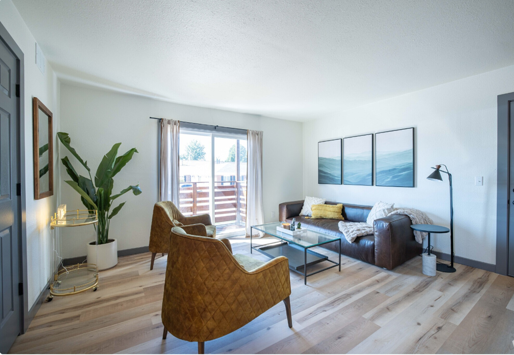 a living room with a couch and chairs and a glass table