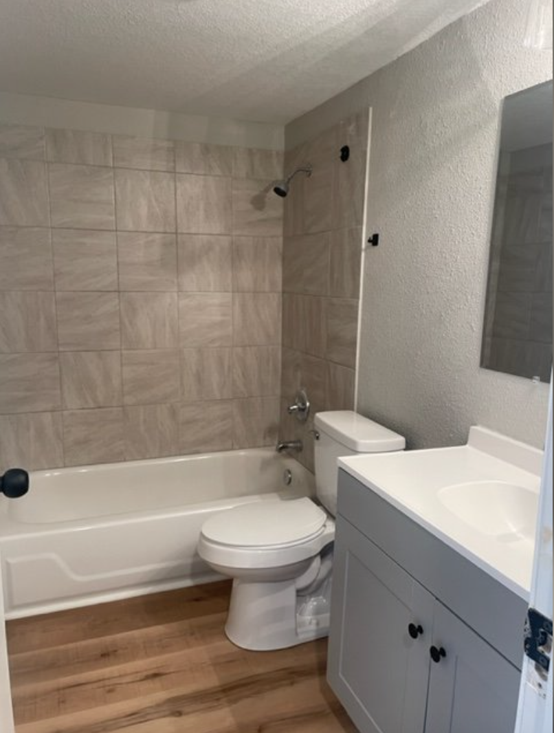 a bathroom with a toilet and a tub and a sink
