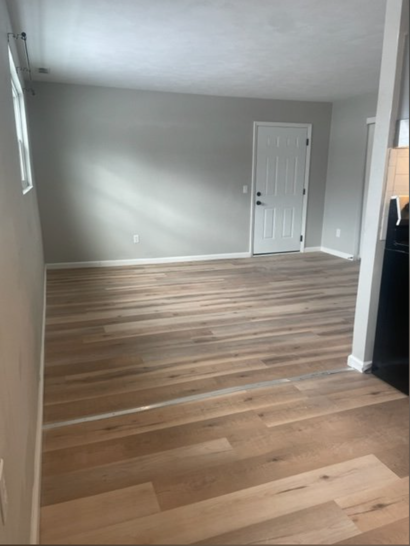 a living room with wooden floors and a white door