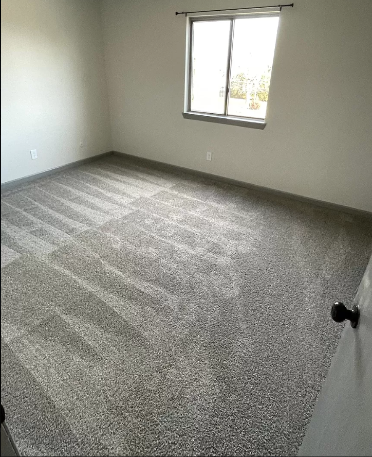 a room with a carpeted floor and a window