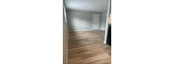 a living room with wooden floors and a white door