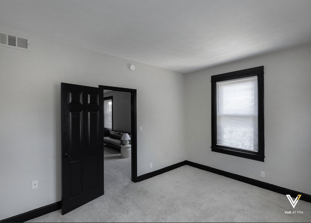 an empty room with a door and a window