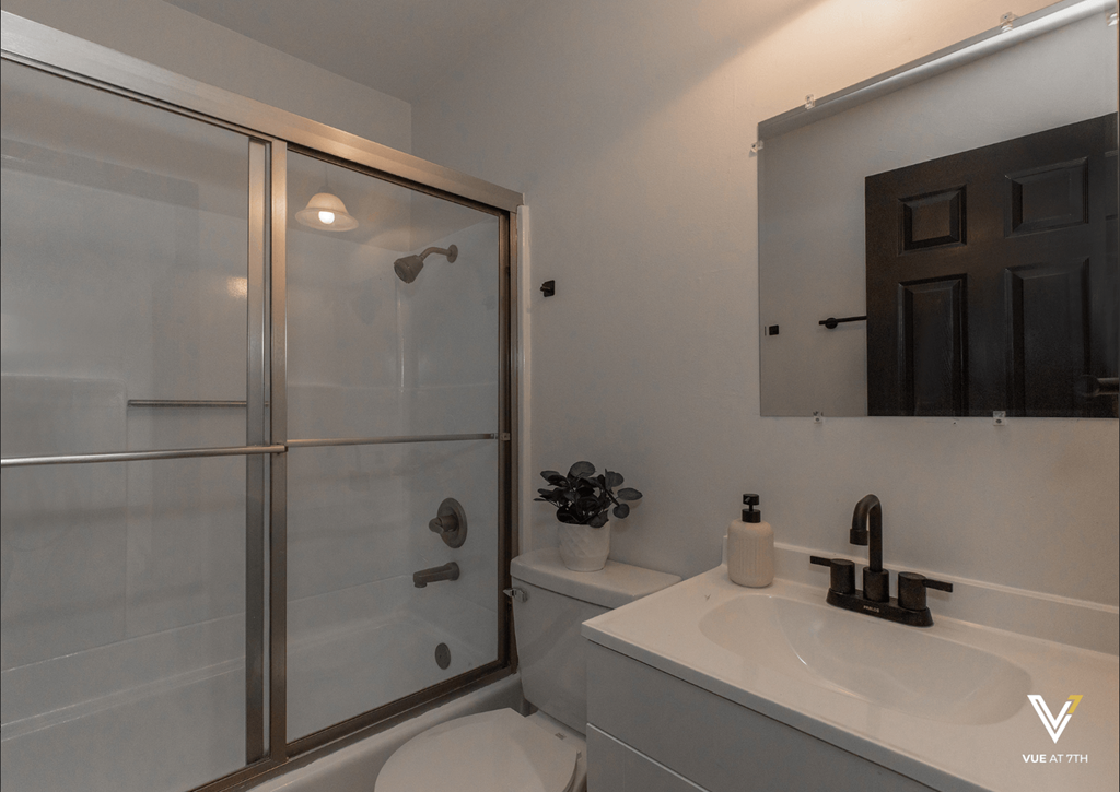 a bathroom with a shower and a sink and a mirror