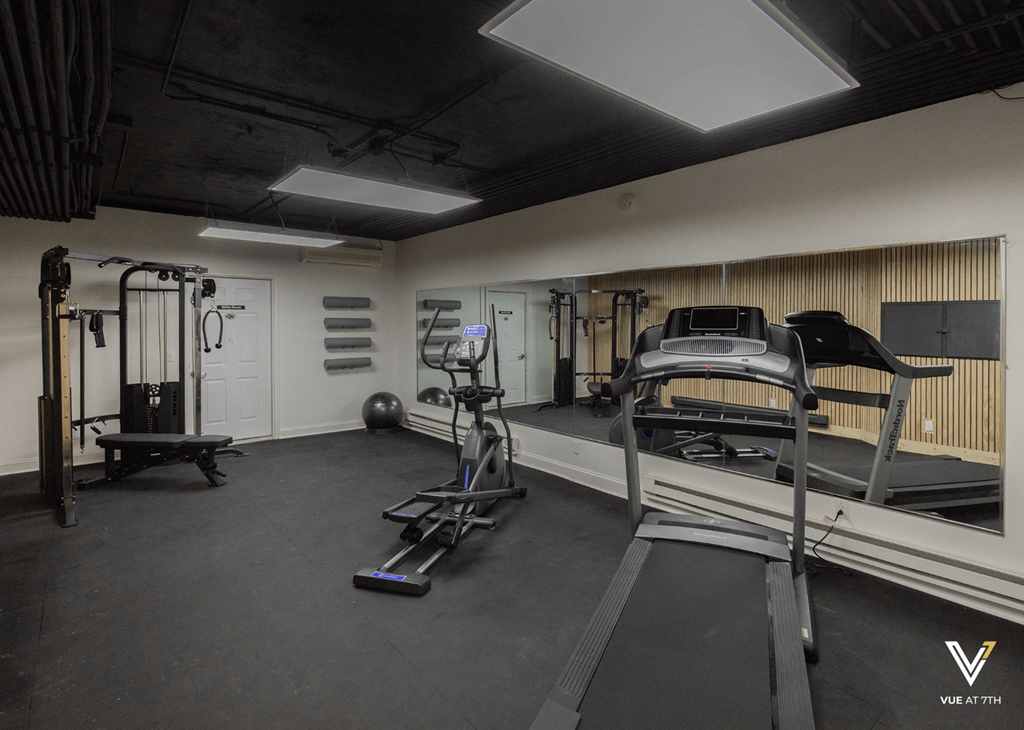 a workout room in a gym with weights and equipment