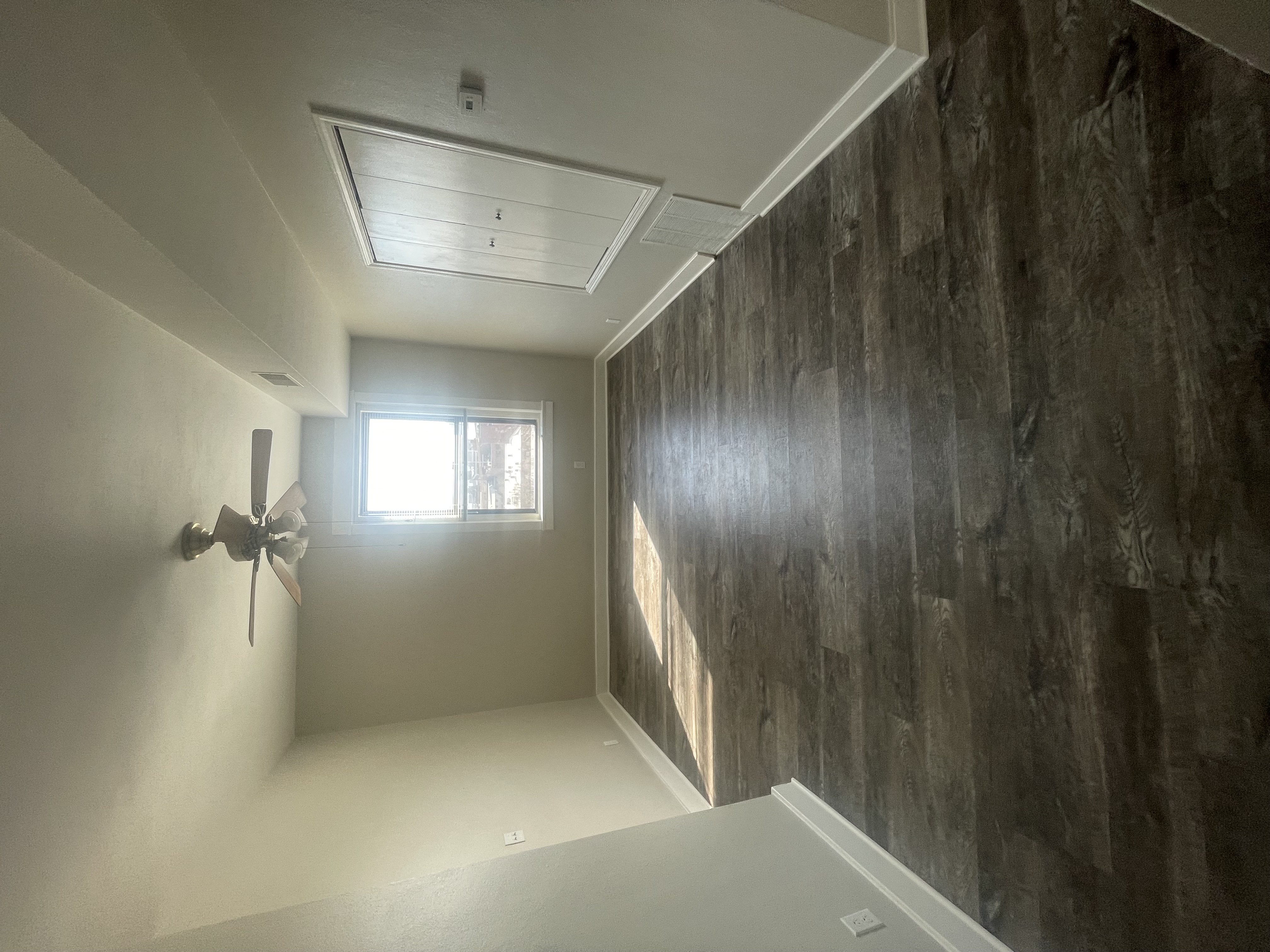 a view of a room with a grey wall and a ceiling fan