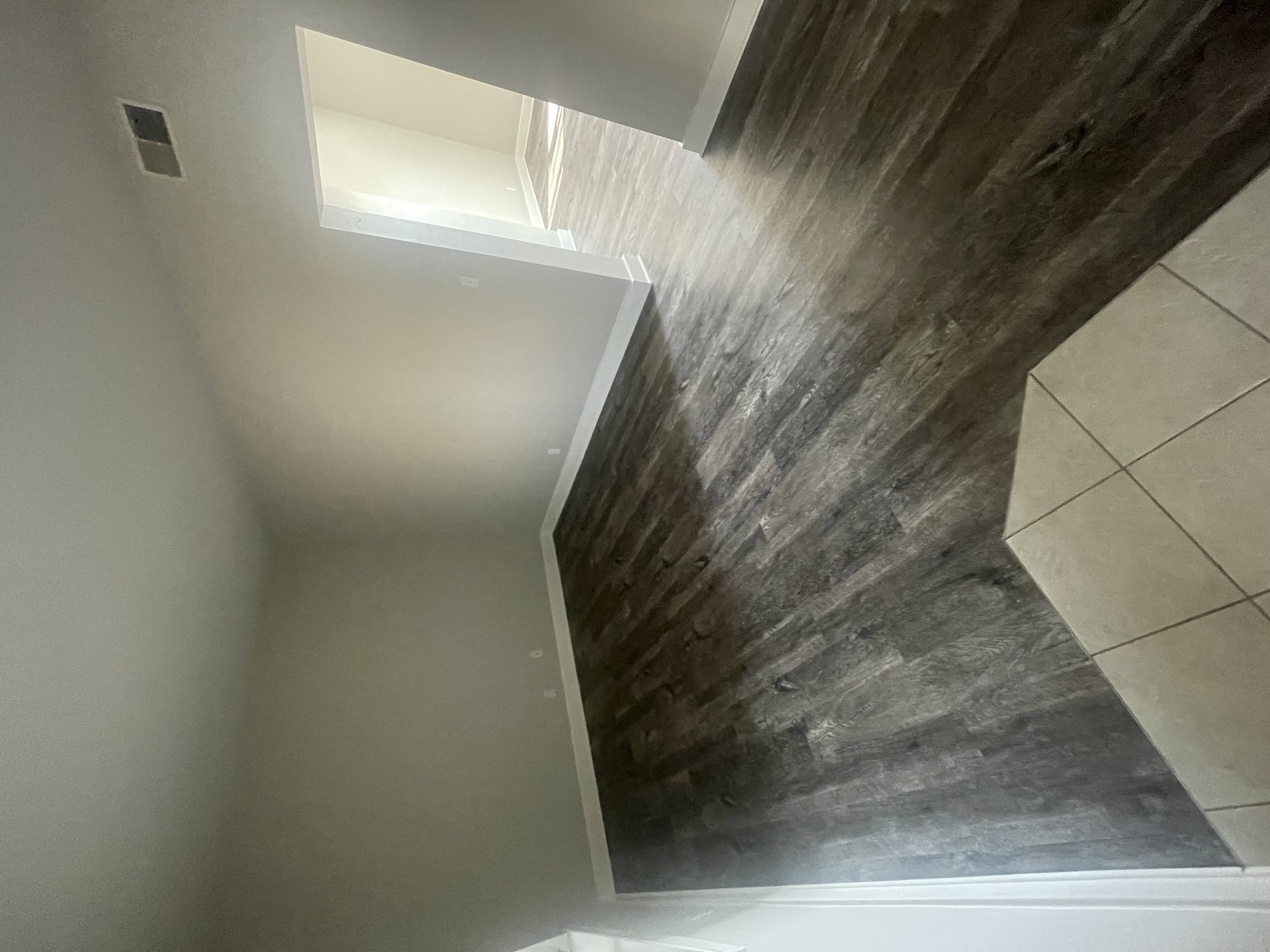 a view of the hallway from the top of the stairs looking down into the bathroom