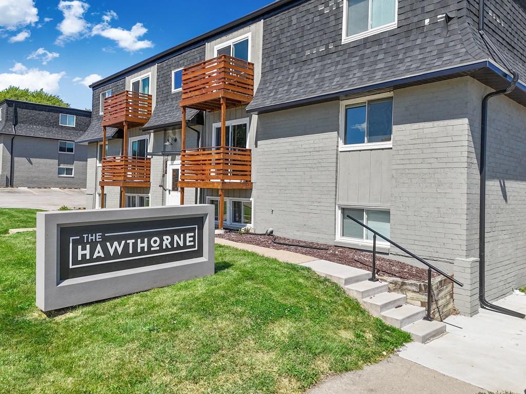the hawthorne apartments exterior with stairs and grass