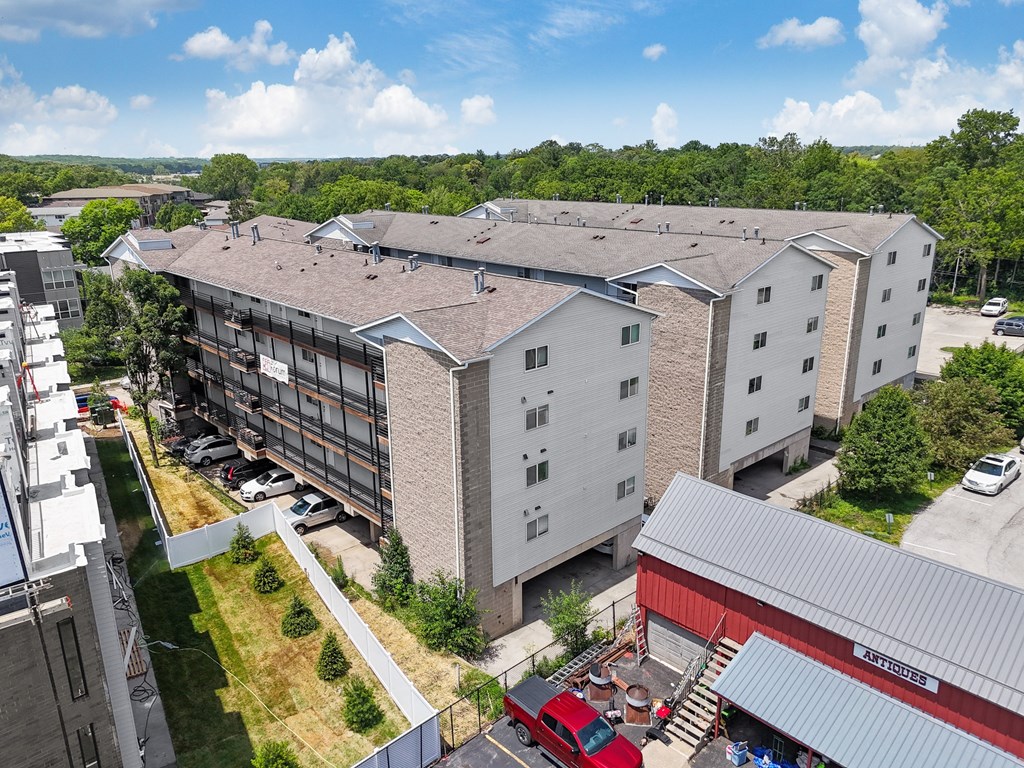 an aerial view of a building with a parking lot and other buildings
