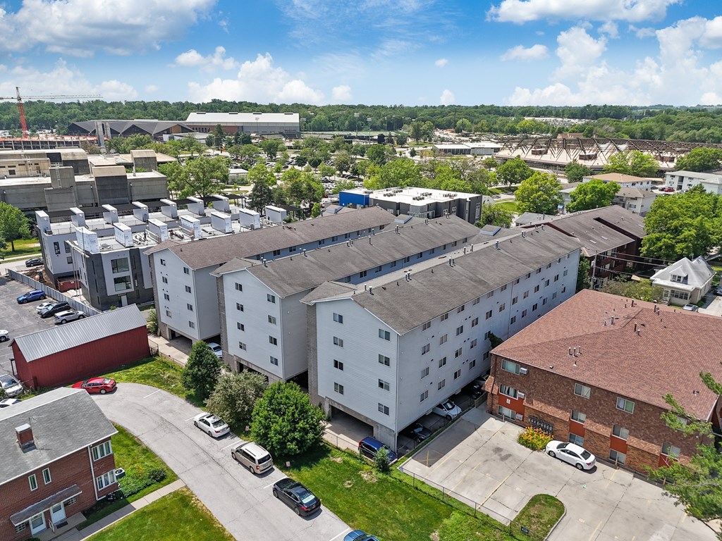 an aerial view of an apartment complex with cars parked in a parking lot
