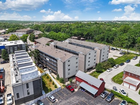 an aerial view of a building with cars parked in a parking lot