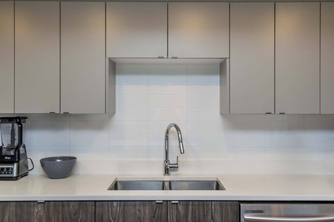 A modern kitchen with a sink and a blender on the counter.