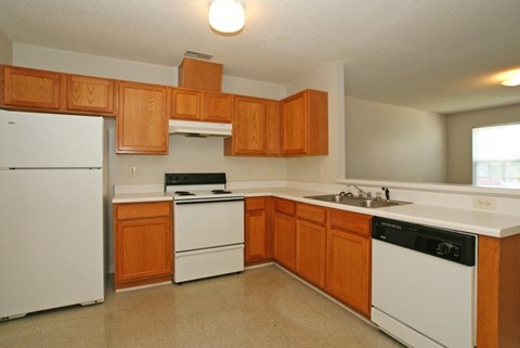 A kitchen with wooden cabinets and white appliances.